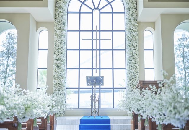 祭壇の先に海と空を一望するチャペル。大きな窓から光が降り注ぎ、海へ続くバージンロードが輝きを放つ。